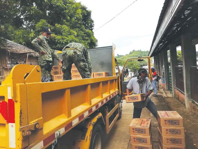 Volunteers unload boxes of relief goods from the Department of Social Welfare and Development for residents affected by the enhanced community quarantine in Batad, Iloilo. The province of Iloilo is currently under the strictest lockdown due to a surge in COVID cases. DSWD-6