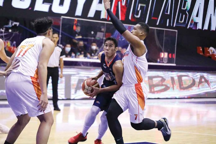 Meralco Bolts’ Rey Mark Belo (center) attacks the defense of NorthPort Batang Pier’s Sidney Onwubere (right) during their 2021 PBA Philippine Cup game on Friday at the Ynares Sports Arena in Pasig City. PBA MEDIA BUREAU