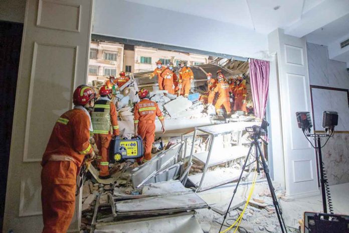 Rescue workers work at the site where a hotel building collapsed in Suzhou, Jiangsu province, China, on Monday. CHINA DAILY VIA REUTERS