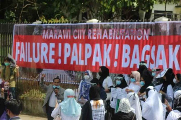 Maranao activists and groups of internally displaced persons display a tarpaulin banner announcing their verdict on how the Duterte administration fared in its promise of making Marawi rise again from the ashes of a five-month war in 2017 against Islamic State terrorists. RYAN D. ROSAURO VIA INQUIRER