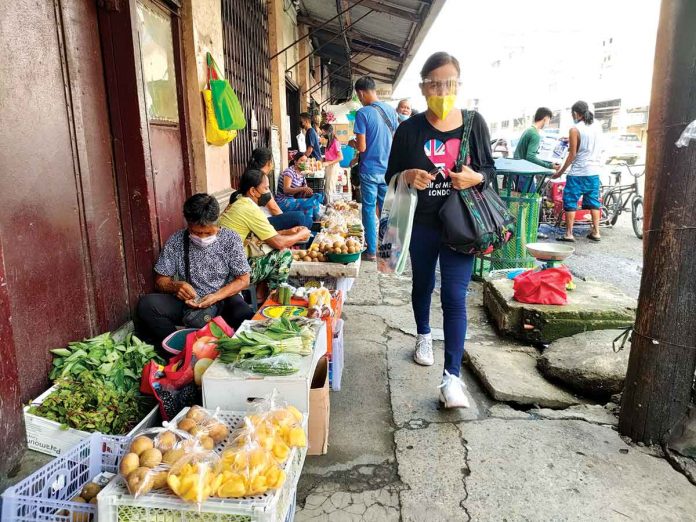 These women trade fruits and vegetables on Iznart Street, Iloilo City. It’s a relief to know, they say, that the city won’t shift to the strictest enhanced community quarantine. Tighter community restrictions would mean lesser customers and income, a vendor tells Panay News. JAPHET FAJARDO/PN