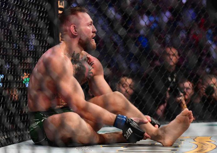 Conor McGregor holds his leg after sustaining an injury while fighting Dustin Poirier during their UFC 264 lightweight mixed martial arts clash at the T-Mobile Arena. GARY A. VASQUEZ-USA TODAY SPORTS