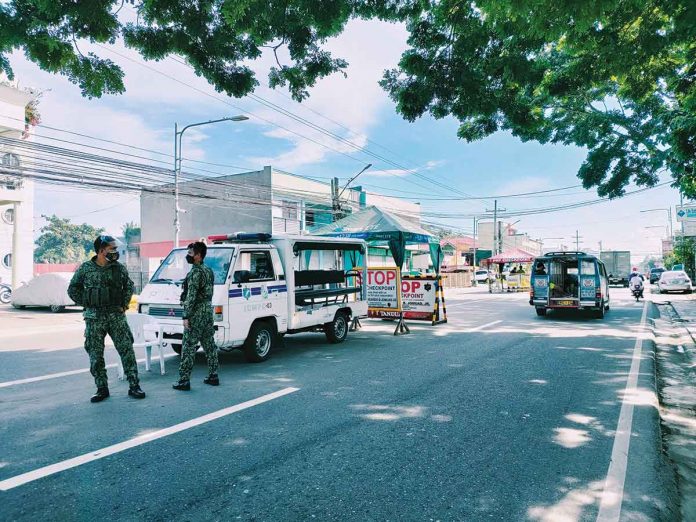 Policemen man a checkpoint in Barangay Tagbak, Jaro, Iloilo City. The village is a “high risk area” for coronavirus disease 2019; it hosts a transport terminal where people converge. PANAY NEWS PHOTO