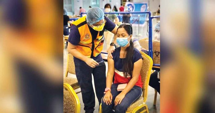 A healthcare worker administers the coronavirus disease 2019 vaccine to a woman in Iloilo City. As of August 15, at least 12.5 million Filipinos were fully vaccinated against coronavirus. The government aims to inoculate at least 58 million of its over 100 million population by the end of the year. JERRY TREÑAS