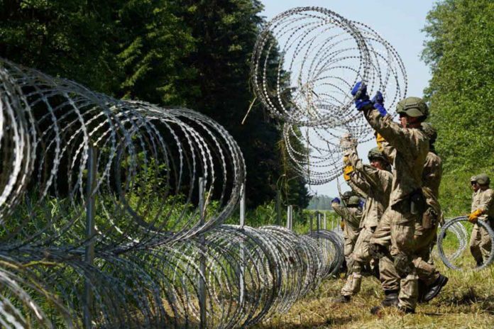 Lithuanian army soldiers install razor wire on the border with Belarus in Druskininkai, Lithuania. REUTERS/JANIS LAIZANS