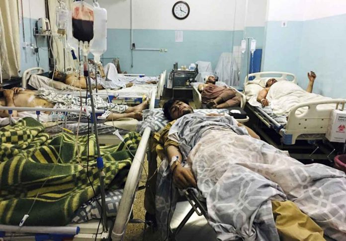 Wounded Afghans lie on a bed at a hospital after a deadly explosion outside the airport in Kabul, Afghanistan, on Thursday. AP/MOHAMMAD ASIF KHAN