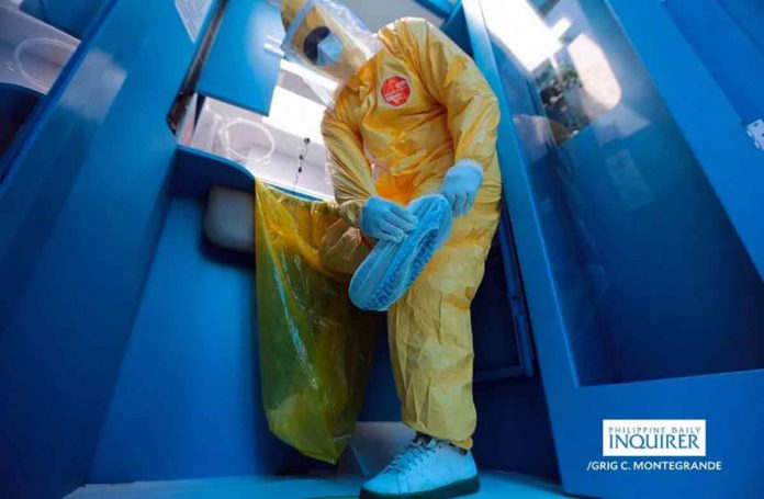 A health worker assists residents of Baesa, Quezon City to undergo swabbing at the mobile testing unit parked along Mendez Street. The mobile unit goes around the communities to test residents for the coronavirus disease 2019. INQUIRER/GRIG MONTEGRANDE