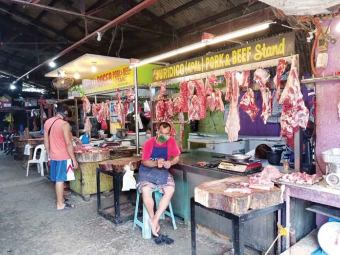 A vendor tends his beef and pork stand in a market in Pavia, Iloilo. The national government lost P1.356 billion after reducing the tariff for imported pork, but the Department of Agriculture and the Department of Trade and Industry claimed that consumers have benefitted from the tariff cut on pork imports. PN FILE PHOTO