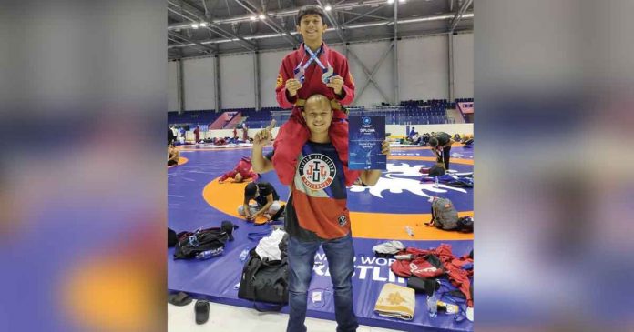 David Zaldarriaga (top) proudly displays the medals he won in the United World Wrestling Grappling World Championships Cadets & Juniors UFA 2021 in Ufa, Russia, with his father, Zony. ZONY ZALDARRIAGA