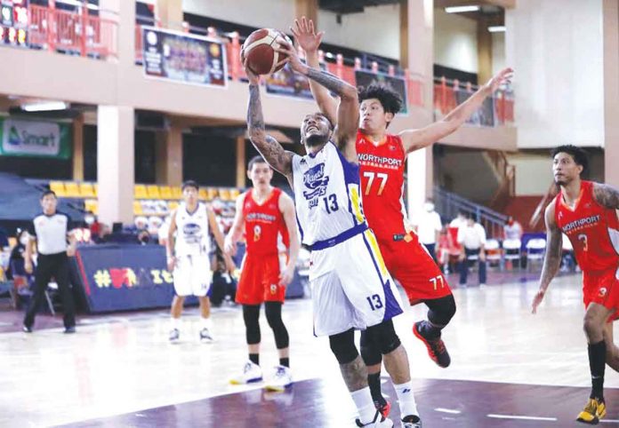 Calvin Abueva (13) of the Magnolia Pambansang Manok Hotshots attempts an inside shot while being defended from behind by Kevin Ferrer (77) of NorthPort Batang Pier during Friday's PBA Philippine Cup match. The Hotshots advanced to the quarterfinals with a 90-89 victory over the Batang Pier. PBA