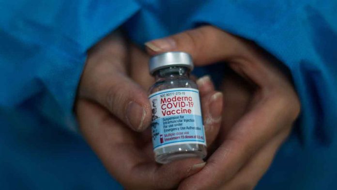 A pharmacist in Kanagawa prefecture in Japan discovers several black particles in one vial of Moderna's coronavirus disease 2019 while checking for foreign substances before using the vaccine. GETTY IMAGES