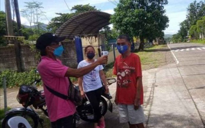 A barangay official in Idio, Sebaste town checks the body temperature of a resident in their barangay border control in this undated photo. PHOTO COURTESY OF ANTIQUE LNB