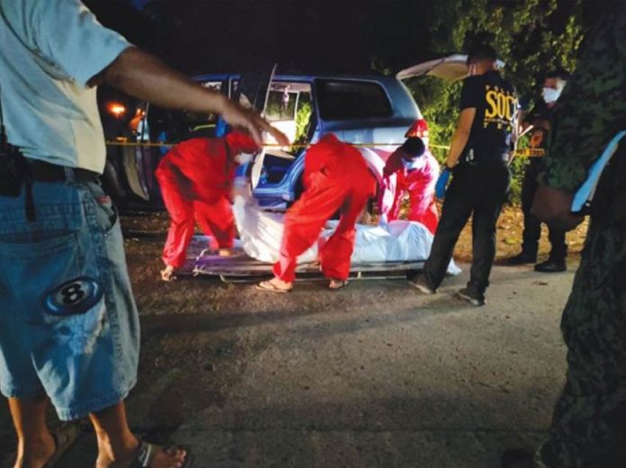 Authorities secure the body of a businesswoman found rotting in a sport utility vehicle in Barangay Inangayan, Santa Barbara, Iloilo late afternoon yesterday. The cause of her death remained unclear. PANAY NEWS PHOTO