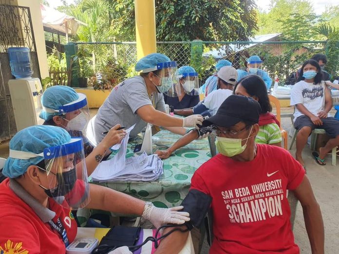 Healthcare workers check the blood pressure of residents of Barangay Gumboc, Leon, Iloilo prior to inoculation of AstraZeneca vaccine against coronavirus disease 2019 in the ongoing “Bakuna sa Barangay” of the Iloilo provincial government. PROVINCIAL HEATH OFFICE