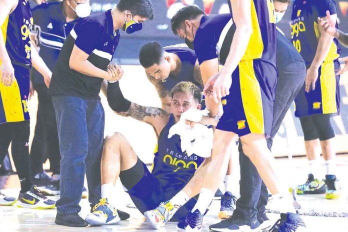 TNT Tropang Giga’s John Paul Erram gets help from teammates after crashing to the court in the second quarter of Game 4 of the 2021 PBA Philippine Cup semifinals series against the San Miguel Beermen. PBA MEDIA BUREAU 