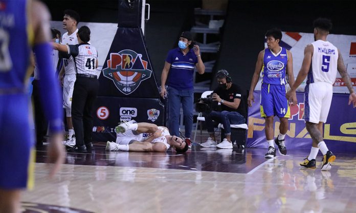 TNT Tropang Giga’s Jeth Troy Rosario grimaces in pain while on the floor following his Game 3 injury. PBA MEDIA BUREAU