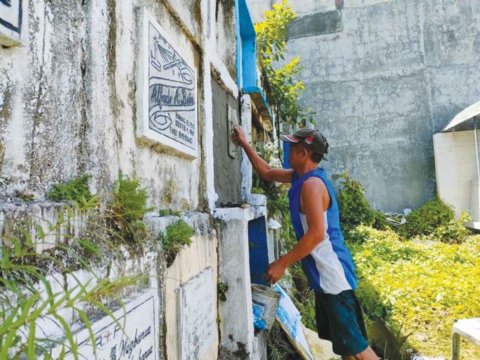 The people of San Jose, Antique are being enjoined to start cleaning the tombs of their dead loved ones prior to the scheduled visiting days (Oct. 25 to 28). Photo shows a man cleaning a tomb at the San Jose Catholic Cemetery. PHOTOS BY JAP FAJARDO