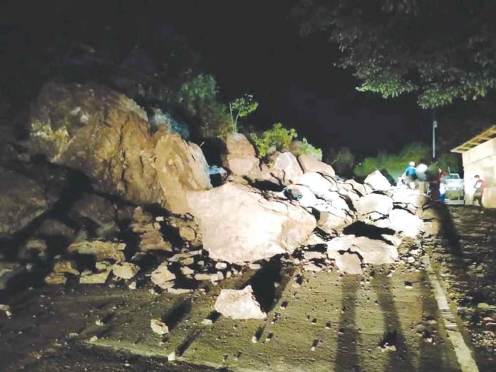 Large boulders block the eco-translink highway in San Carlos City, Negros Occidental late Friday night. SAN CARLOS CITY DRRMO