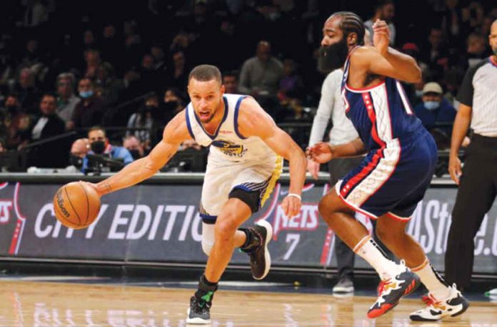 Golden State Warriors’ Stephen Curry dribbles the ball while being defended by Brooklyn Nets’ James Harden. FANSIDED PHOTO