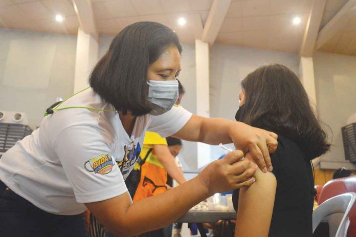 Photo show a minor receiving an anti-virus shot in Iloilo City. Panay News