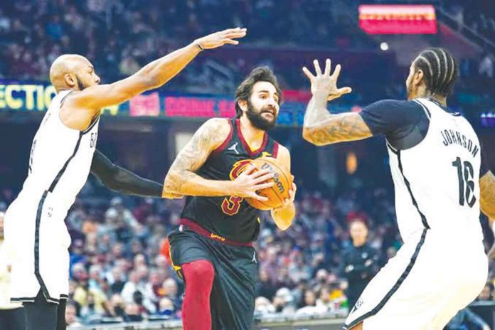 Cleveland Cavaliers’ Ricky Rubio (center) drives between Brooklyn Nets’ Jevon Carter (left) and James Johnson during the first half of an NBA basketball game on Nov. 22, 2021 in Cleveland. AP PHOTO, TONY DEJAK