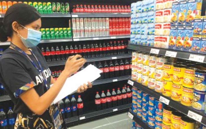 An employee of the Department of Trade and Industry - Antique checks the prices of basic commodities at a retail store in San Jose de Buenavista town. Because the province is under a state of calamity, an automatic price ceiling is in effect based on November prices. PHOTO COURTESY OF DTI-ANTIQUE