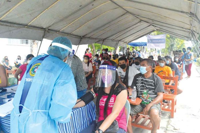 A healthcare worker checks the blood pressure of a resident in the Rural Health Unit of Zarraga, Iloilo in the first “Bayanihan Bakunahan” national coronavirus disease 2019 vaccination days. PANAY NEWS PHOTO