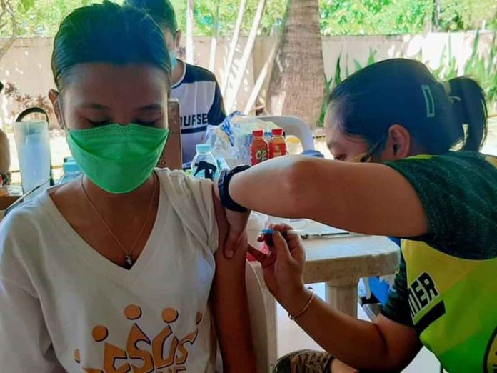 A young woman gets a dose of the vaccine against coronavirus disease in Capiz.