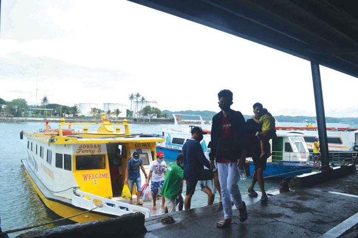 Severe tropical storm “Odette” cancelled several sea trips just before noon yesterday. Photo shows passengers from the island province of Guimaras disembarking from a pump boat at the Parola wharf in Iloilo City hours after Signal No. 1 was hoisted over Western Visayas. PANAY NEWS PHOTO