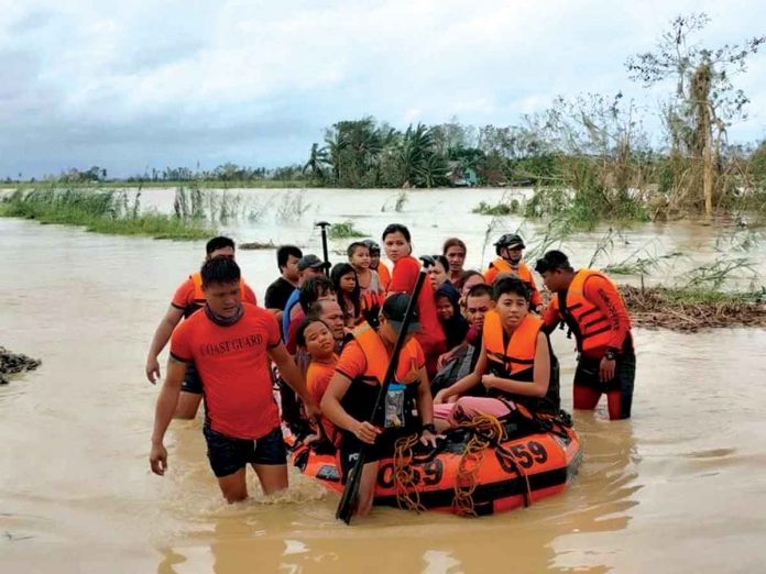 In Negros Occidental, Philippine Coast Guard personnel rescue families from rising floodwaters in the southern part of the province when super typhoon “Odette” struck on Dec. 17. The cities of Kabankalan and Sipalay and the town of Ilog are the hardest hit areas.