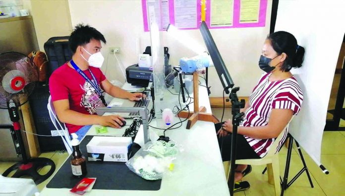 A resident (right) of Guimaras registers for a national identification card. PSA PHOTO