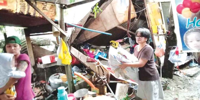 A family tries to salvage valuables from their collapsed house in Barangay Calaparan, Arevalo, Iloilo City. A huge tree that super typhoon “Odette” uprooted fell to their house in the wee hours of Friday, Dec. 17, 2021. Fortunately, all the household members managed to get out of the house alive. PN PHOTO