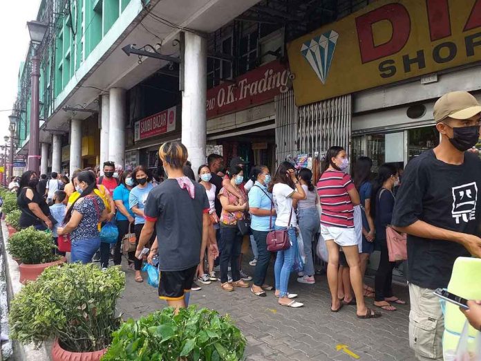 SHOPPING RUSH. People wait for their turn to enter a shopping center on JM Basa Street, Iloilo City. Notice that they are no longer observing physical distancing – a pandemic health safety protocol. The Department of Health warns of a possible surge in coronavirus disease cases after the holiday season. IME SORNITO/PN