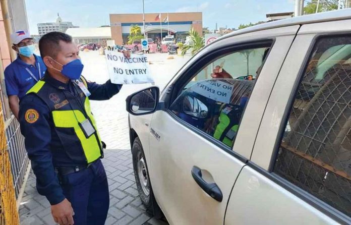 A security guard at the entrance of the Iloilo Fastcraft Terminal reminds a traveles about the area’s pandemic policy – no vaccine, no entry. PN PHOTO