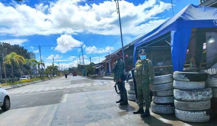 Policemen man a checkpoint in Barangay Ungka, Jaro, Iloilo City. But the national highway is almost empty. Few people are going out. Many are heeding the advice of the city government not to go out unless the trip is essential, due to the rising cases of coronavirus disease 2019. RUBY SILUBRICO