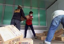 Department of Social Welfare and Development personnel are seen at the repacking and preposition site in Dumarao, Capiz carry family food packs for transport to Dao, Capiz and Negros Occidental. PHOTO COURTESY OF ARNULFO LEAL, DSWD-6