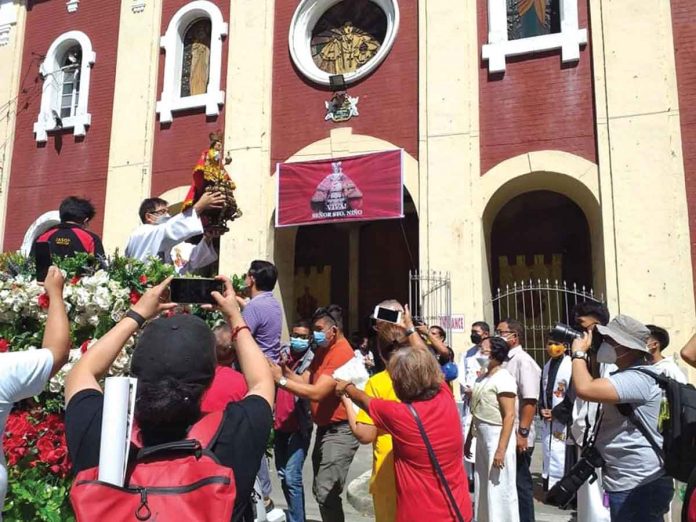 DEVOTION IN MOTION. A priest blesses the faithful with the image of Señor Santo Niño in front of San Jose de Placer Church in Iloilo City before the start of the motorcade on Friday, Jan. 21, 2021. Due to the coronavirus pandemic, the motorcade temporarily replaced the traditional crowd-drawing Dinagyang Festival fluvial procession in honor of Señor Santo Niño. PN PHOTO