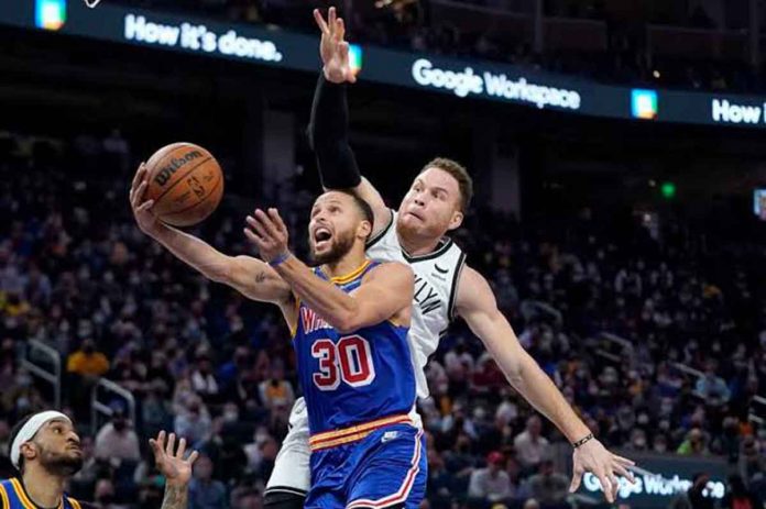 Golden State Warriors’ Stephen Curry goes under the defense of Brooklyn Nets’ Blake Griffin for an inside basket. AP PHOTO