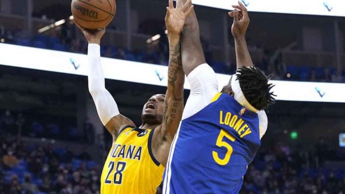 Indiana Pacers’ Keifer Sykes scores against the defense of Golden State Warriors’ Kevon Looney. GETTY IMAGES