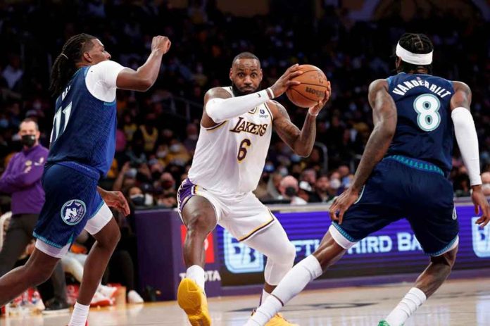 Los Angeles Lakers forward LeBron James (6) drives between Minnesota Timberwolves center Naz Reid (11) and Jarred Vanderbilt (8). PHOTO BY RINGO H.W. CHIU/AP