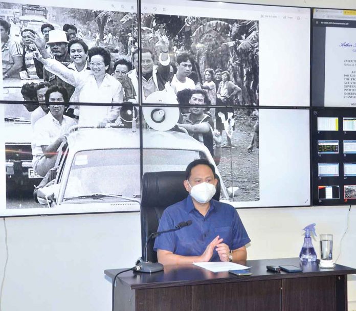 ‘WE DON’T WANT TO FORGET’. The photo behind Gov. Arthur Defensor Jr. of Iloilo was shot in the province of Antique just weeks before the February 1986 People Power Revolution that ousted dictator Ferdinand Marcos. It shows Marcos challenger Corazon Aquino and running mate Salvador Laurel campaigning for the Feb. 7, 1986 snap presidential election. Behind Aquino is the governor’s father, then Assemblyman Arthur Defensor Sr., an opposition leader in Iloilo. CAPITOL PIO PHOTO