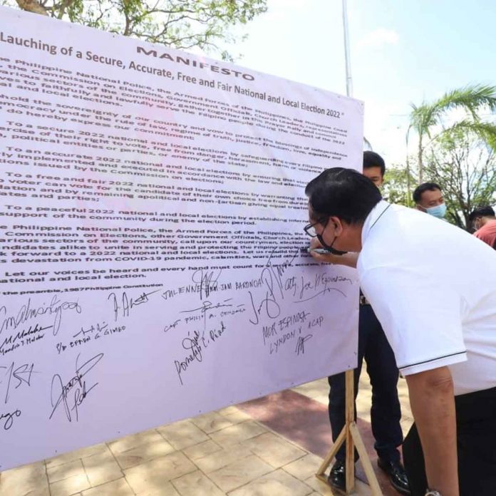 Mayor Jerry Treñas of Iloilo City signs a manifesto for clean and honest 2022 elections during an interfaith prayer for peace and unity, and caravan. ILOILO CITY GOV’T PHOTO