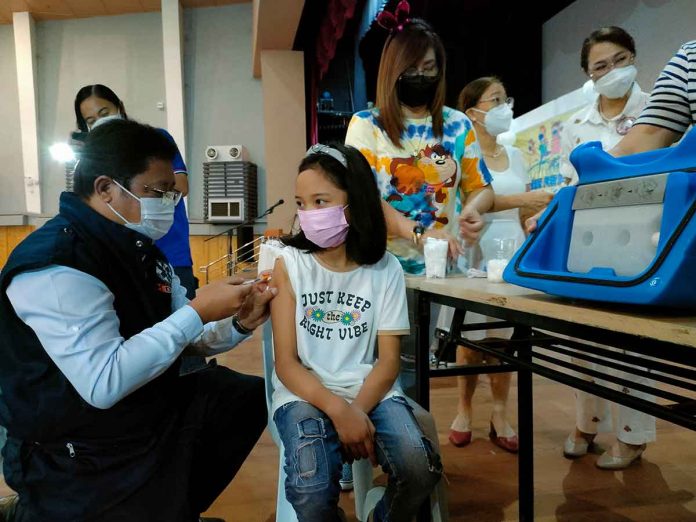 A young girl stays calm while being vaccinated against coronavirus disease by Dr. Adriano Suba-an, director of the Department of Health – Region 6, at the West Visayas State University Cultural Center, one of several vaccination sites of the provincial government of Iloilo. PN PHOTO