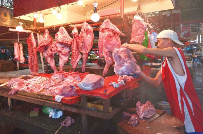 A meat vendor at the Iloilo Terminal Market in Iloilo City prepares his merchandise. The National Meat Inspection Service in Region 6 seeks to strengthen meat inspection to project public health and prevent the entry or spread of African swine fever. PN PHOTO