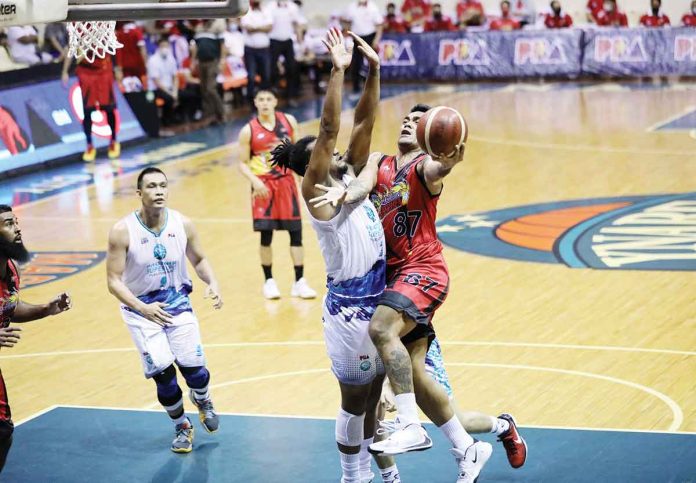 San Miguel beermen’s Vic Manuel attacks the defense of Phoenix Super LPG Fuel masters’ Jason Perkins. PBA PHOTO