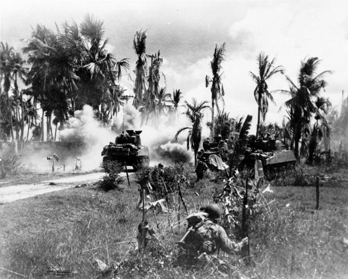 Troops of the 185th Infantry, 40th Division, take cover behind advancing tanks while moving up on Japanese positions on Panay Island. This is one of the shots salvaged from the camera of Lieutenant Robert Fields who was killed in action shortly after it was taken. PHOTO FROM WIKIPEDIA