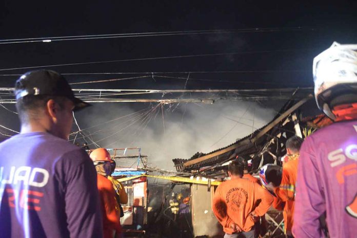 Firefighters and rescuers stand before fire-gutted houses in Barangay Old Airport, Mandurriao, Iloilo City on March 11, 2022. PN PHOTOS