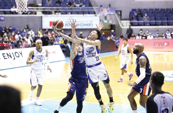 Magnolia Hotshots’ Adrian Wong is clipped by Meralco Bolts’ defense as he goes for a layup.PBA PHOTO