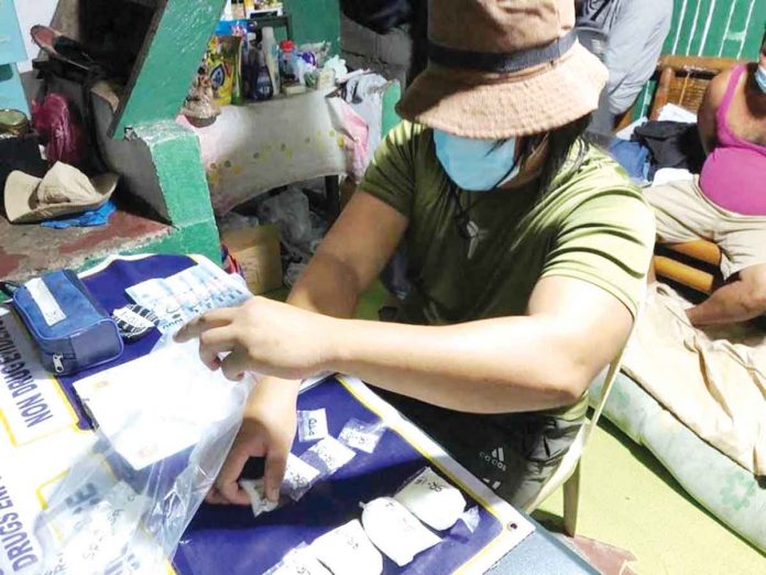 A police operative is conducting an inventory of the items – sachets of suspected shabu – seized in a buy-bust operation in Purok Katilingban, Barangay Banago, Bacolod City.