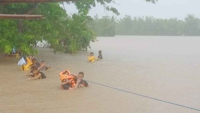 RESCUE OPERATION. Concepcion, Iloilo fire station personnel rescue people trapped in rising floodwaters in low-laying barangays such as Bacjawan Norte, Jamul-Awon and Agnaga. Heavy rains since Sunday night swelled rivers and inundated villages. PHOTO FROM BFP-6 CONCEPCION FACEBOOK PAGE